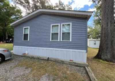 After look of project with GAF Timberline HDZ shingles in Charcoal and CertainTeed MainStreet vinyl siding in Flagstone