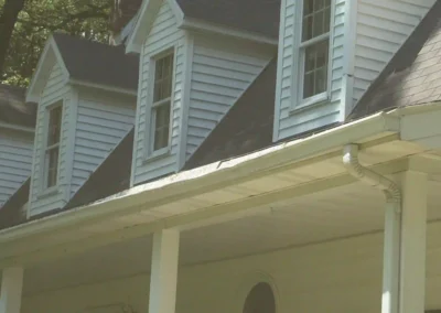 Before look of roof system with weathered shingles, inconsistent ventilation, and a gutter system