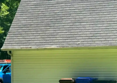 Before look of roof system with weathered shingles, inconsistent ventilation, and a gutter system