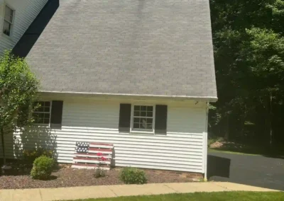 Before look of roof system with weathered shingles, inconsistent ventilation, and a gutter system